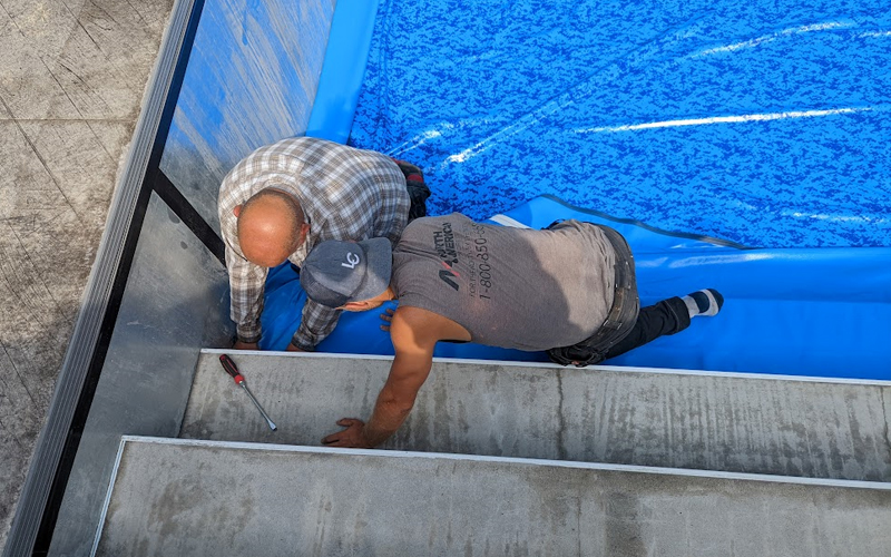 Pool liner being repaired by crew